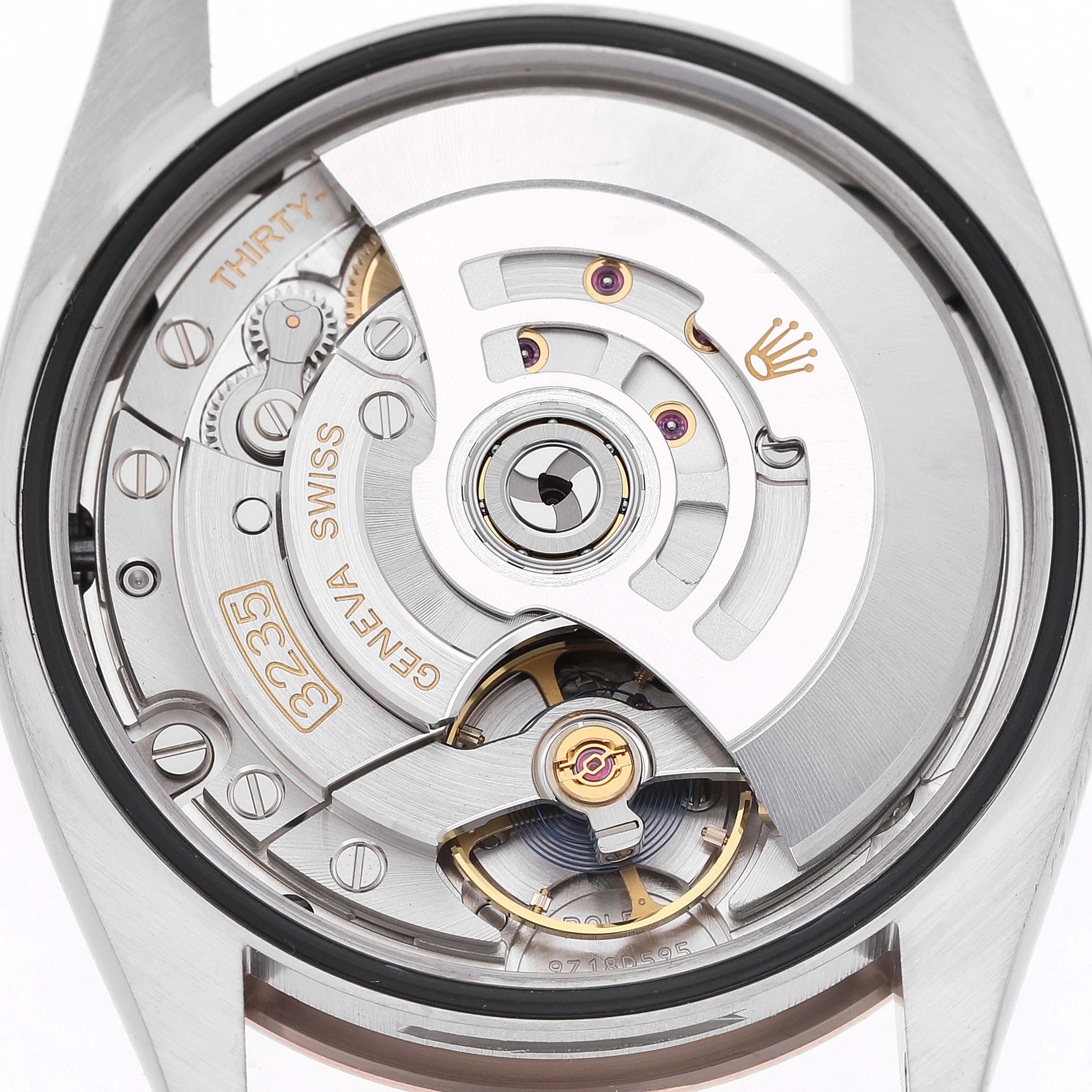 The image shows the movement of a Rolex Datejust 126231 Men's Steel and Gold (two tone) Black Dial watch from the back, highlighting gears and the rotor.