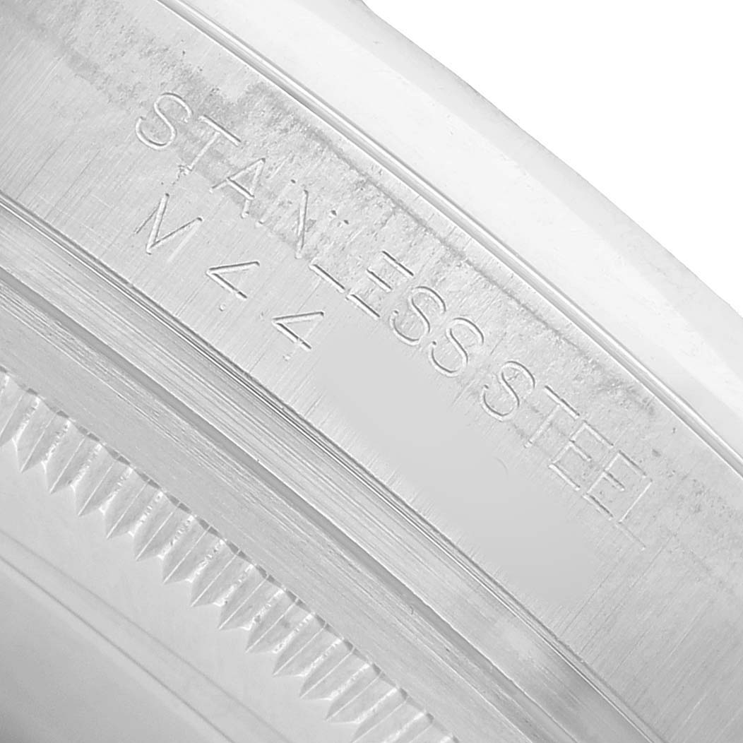 The image shows an angled close-up of the stainless steel case with bezel details of a Rolex Datejust 116200 Men's Stainless Steel White Dial watch.