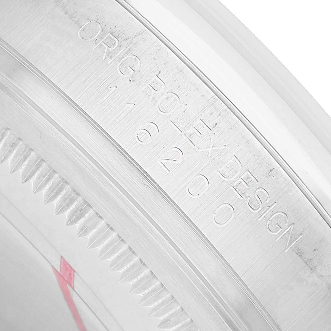 The image shows the inner bezel of a Rolex Datejust 116200 Men's Stainless Steel White Dial, featuring engraved text, viewed at a close angle.