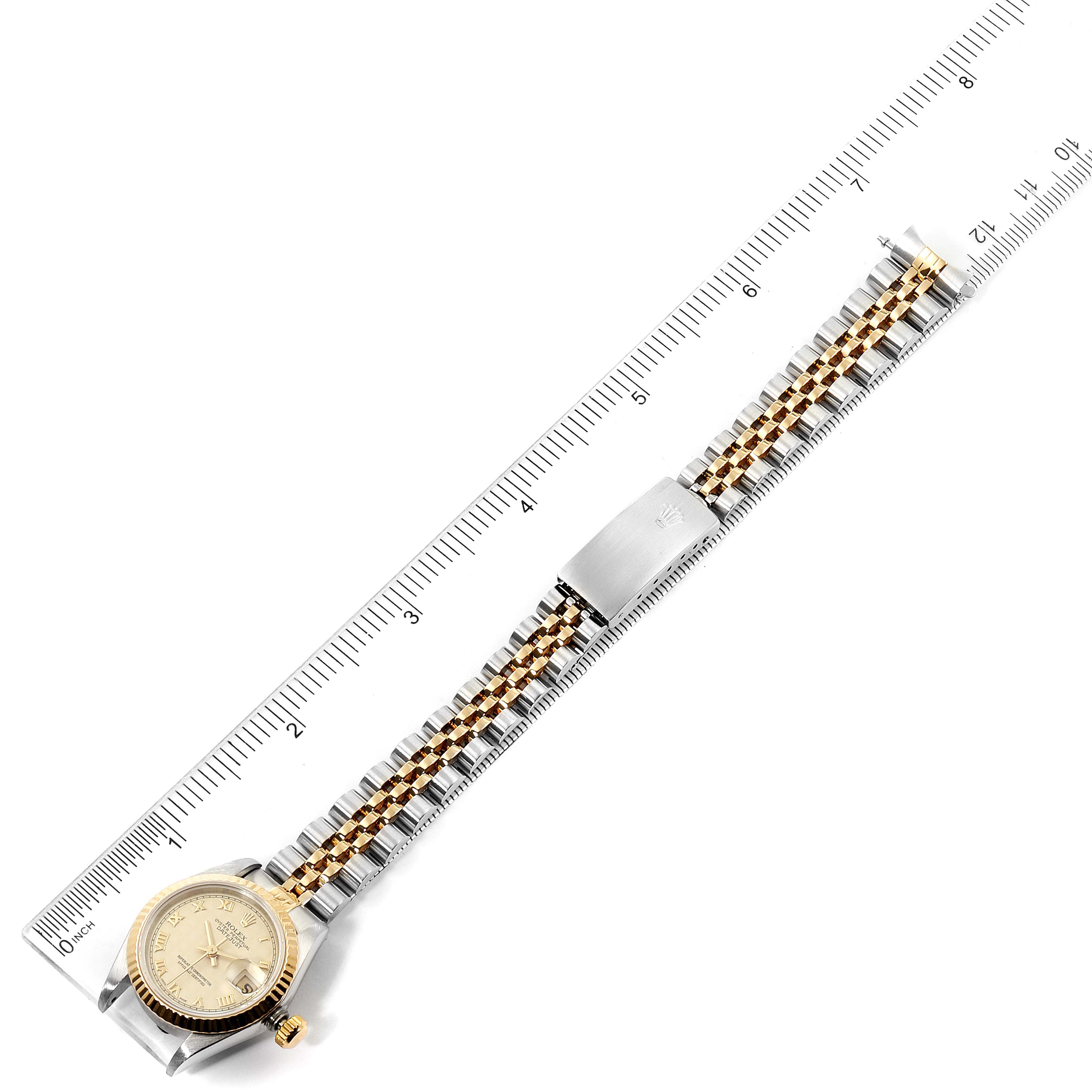 The Rolex Datejust 69173 Women's Steel and Gold (two tone) Beige Dial 69173 Women's Steel and Gold (two tone) Beige Dial watch is shown from a top view, displaying the dial, bezel, and entire band with a ruler for scale.