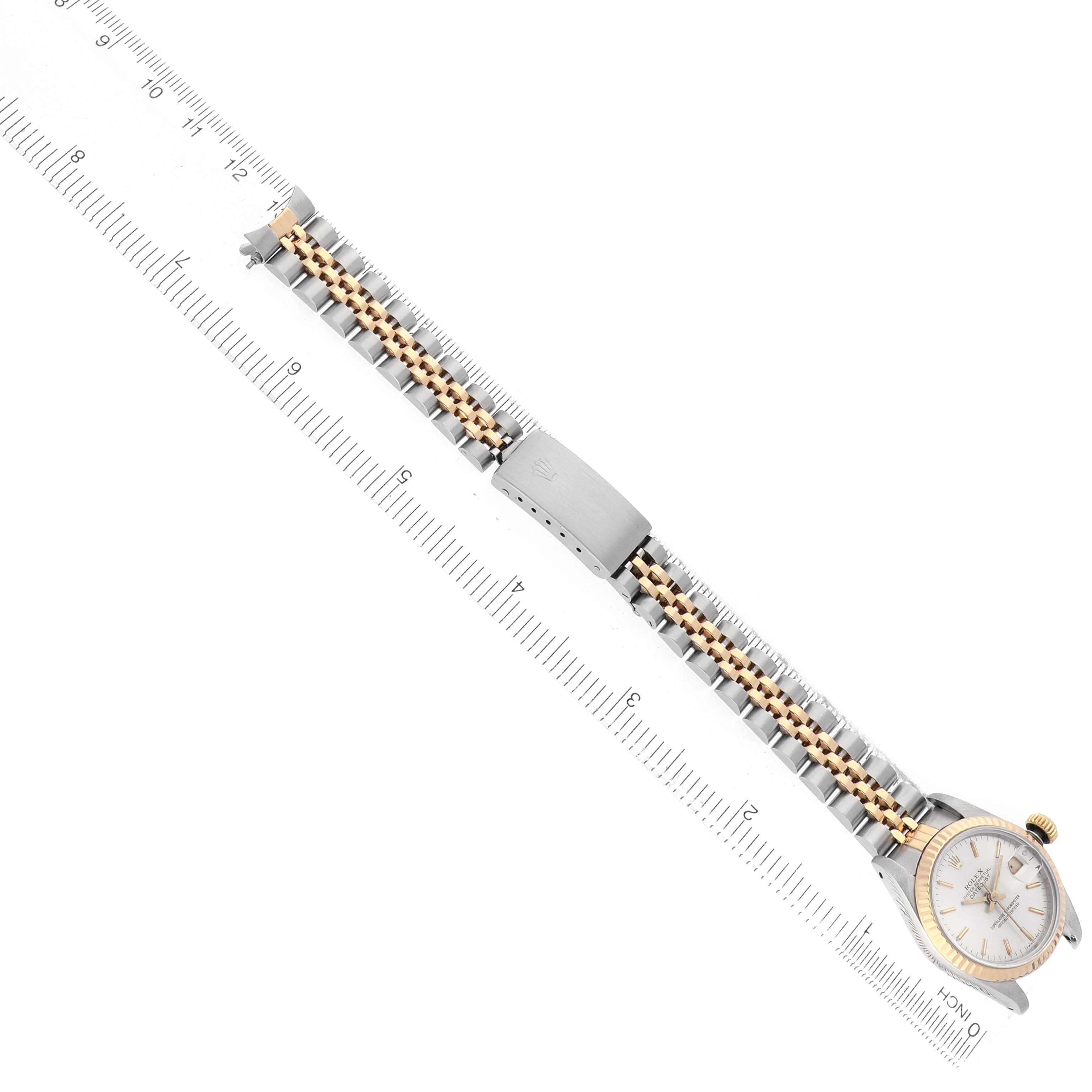 The image shows a Rolex Datejust 69173 Women's Steel and Gold (two tone) Silver Dial watch laid flat, highlighting the bracelet, clasp, and watch face, aligned with a ruler.