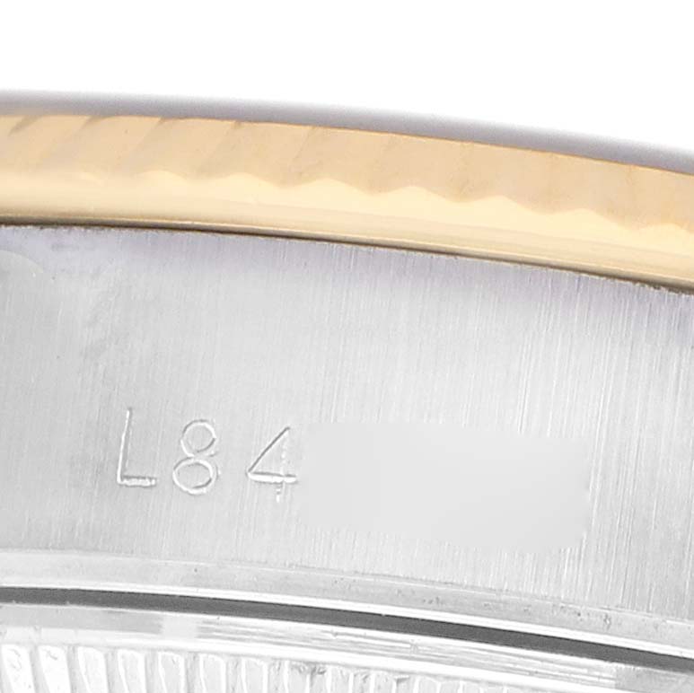 The image shows a close-up of a Rolex Datejust 69173 Women's Steel and Gold (two tone) Silver Dial watch's bezel and engraved serial number.