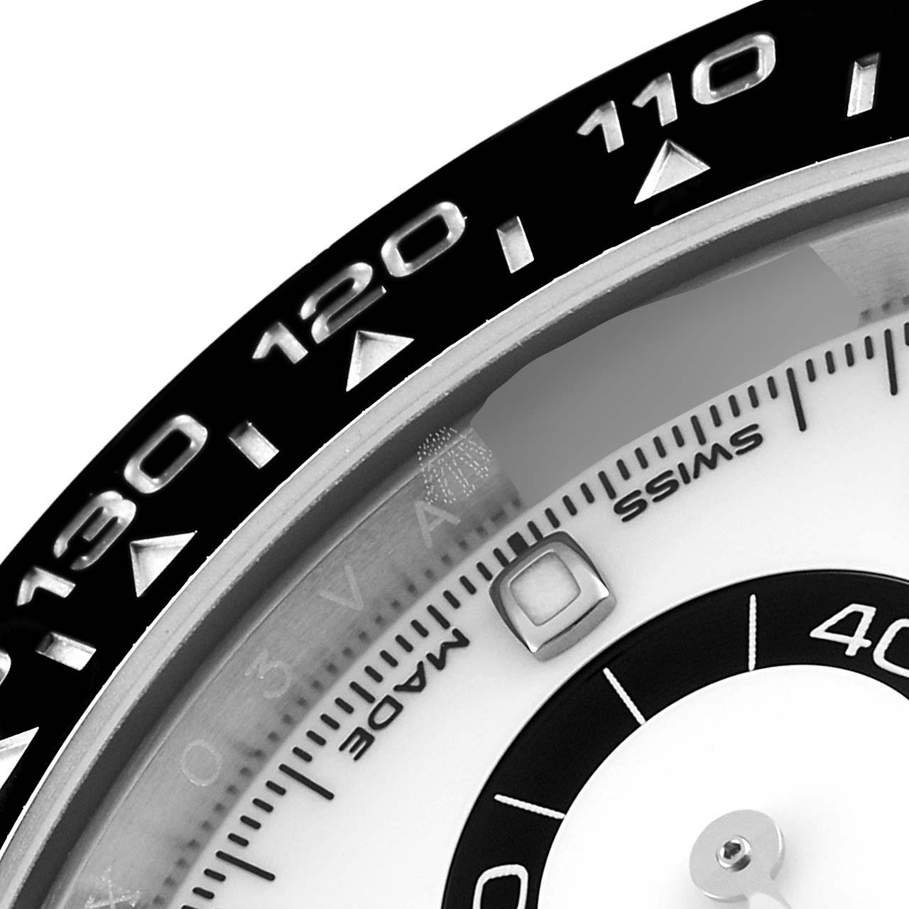 The image shows a close-up of the bezel and part of the dial of a Rolex Daytona 116500 Men's Stainless Steel White Dial 116500 Men's Stainless Steel White Dial watch.