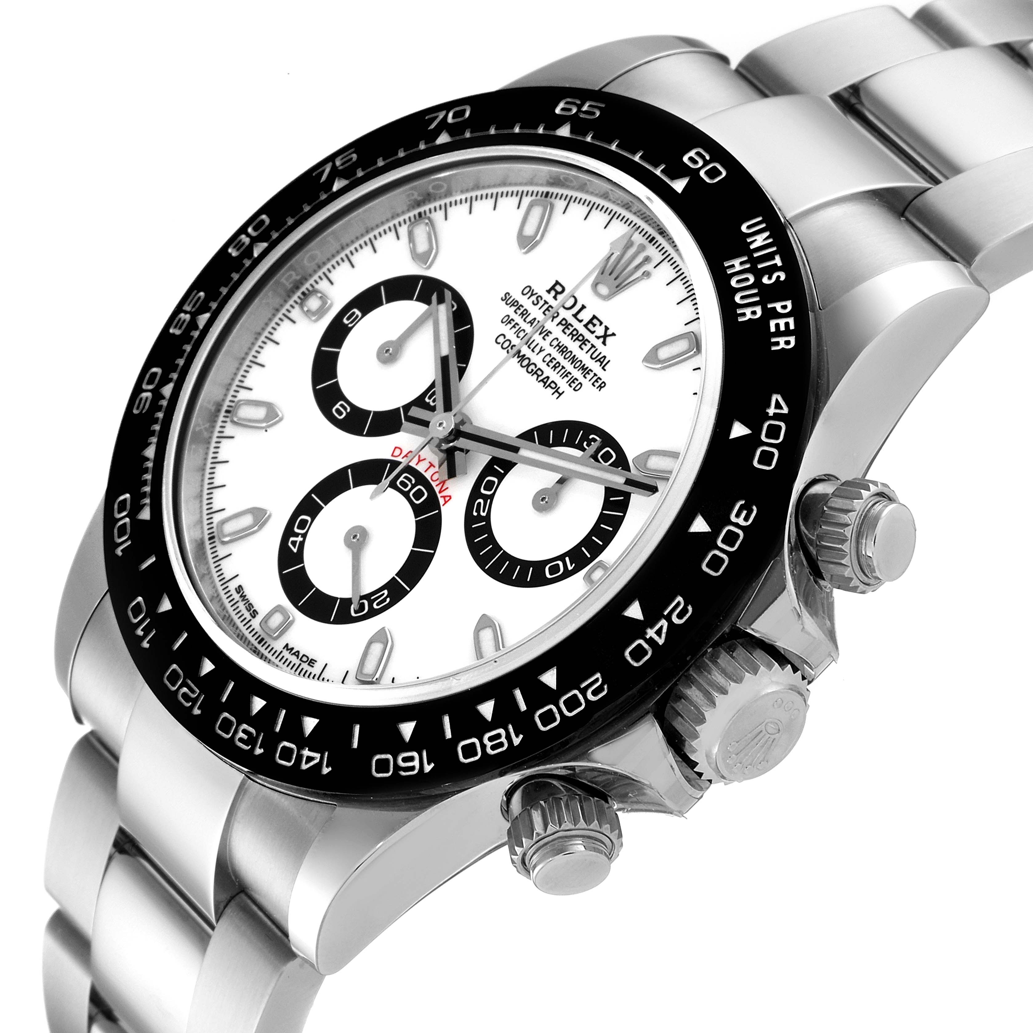 The image shows a close-up angled view of a Rolex Daytona 116500 Men's Stainless Steel White Dial 116500 Men's Stainless Steel White Dial watch, highlighting the dial, bezel, crown, and bracelet.