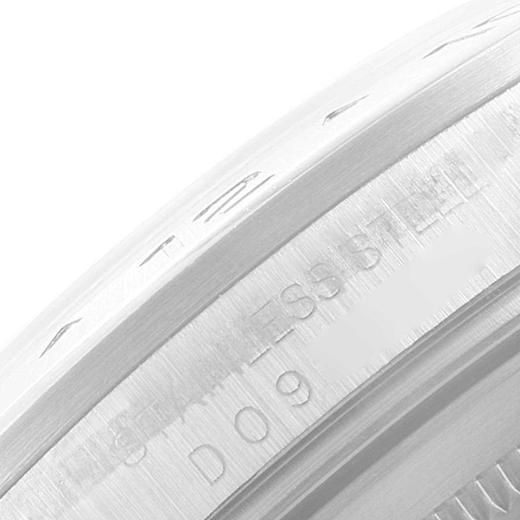 This close-up image of the Rolex Explorer 16570 Men
s Stainless Steel White Dial 16570 Men
s Stainless Steel White Dial watch shows the edge of the bezel and part of the case, indicating "STAINLESS STEEL" and a serial number.