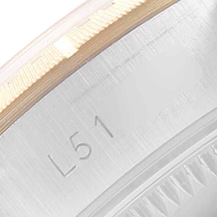 This image shows a close-up of the bezel and part of the case of the Rolex Oyster Perpetual 67243 Women's Steel and Gold (two tone) Silver Dial 67243 Women's Steel and Gold (two tone) Silver Dial watch with engraved details.