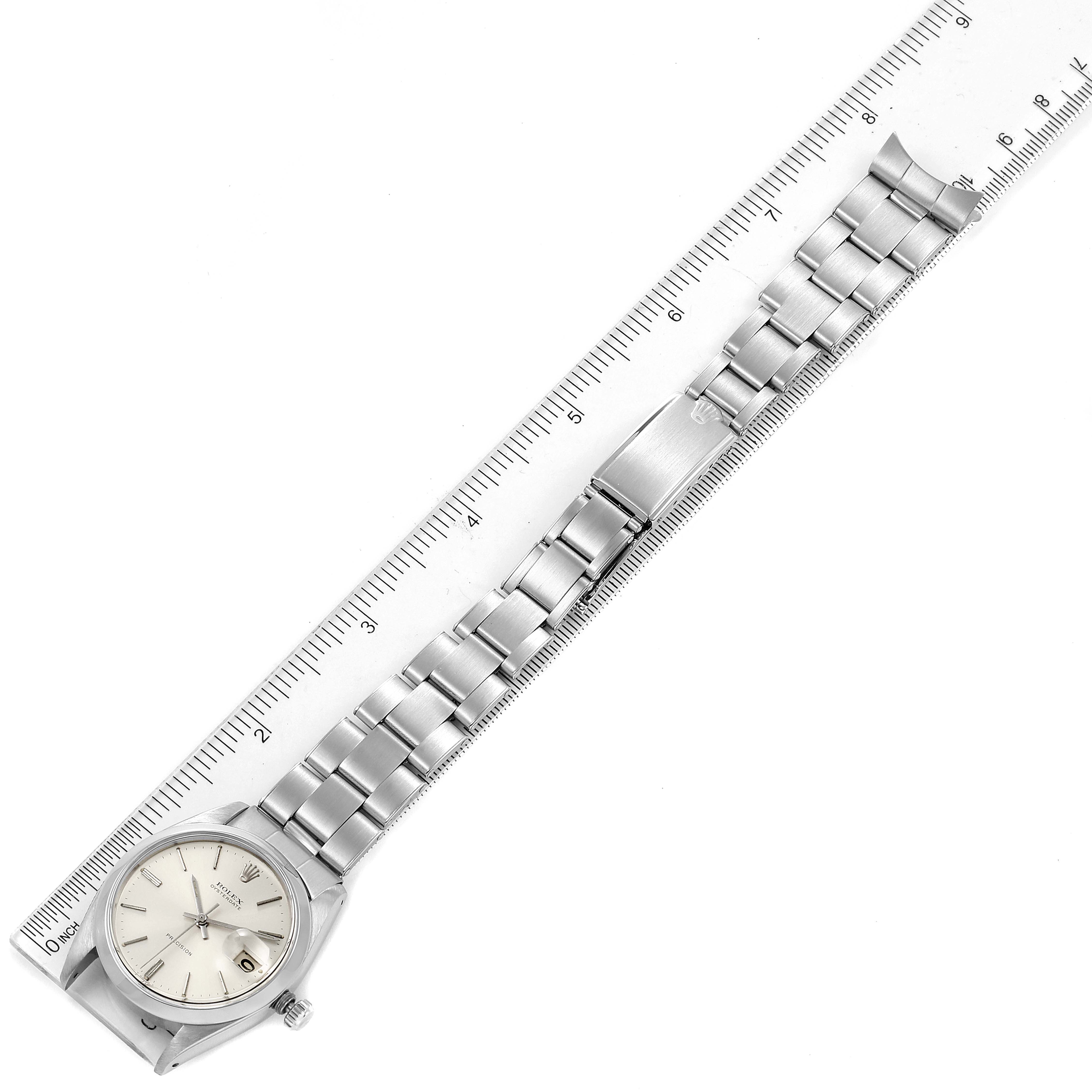 The Rolex Vintage Collection 6694 Men's Stainless Steel Silver Dial watch is shown from a top-down angle with its full bracelet and the face visible next to a ruler.