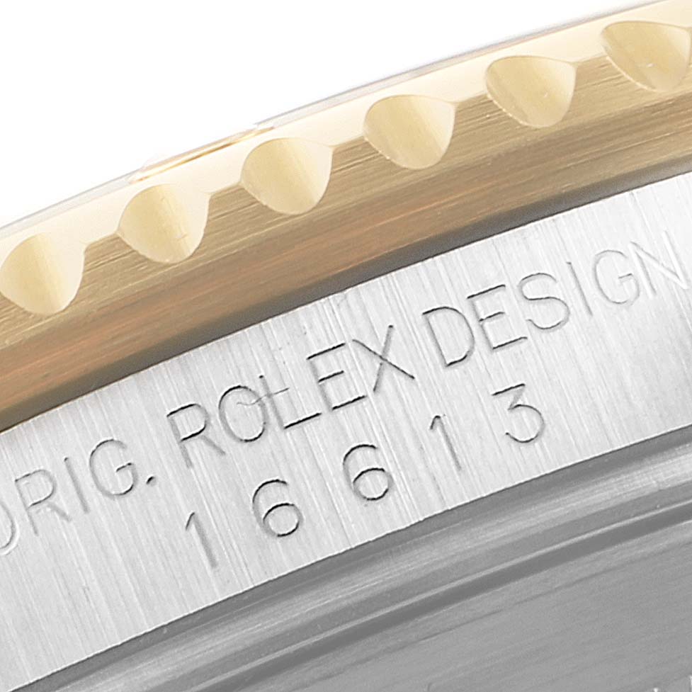 This close-up image of a Rolex Submariner 16613 Men's Steel and Gold (two tone) Blue Dial 16613 Men's Steel and Gold (two tone) Blue Dial shows the engraved model number 16613 and part of the bezel and case.