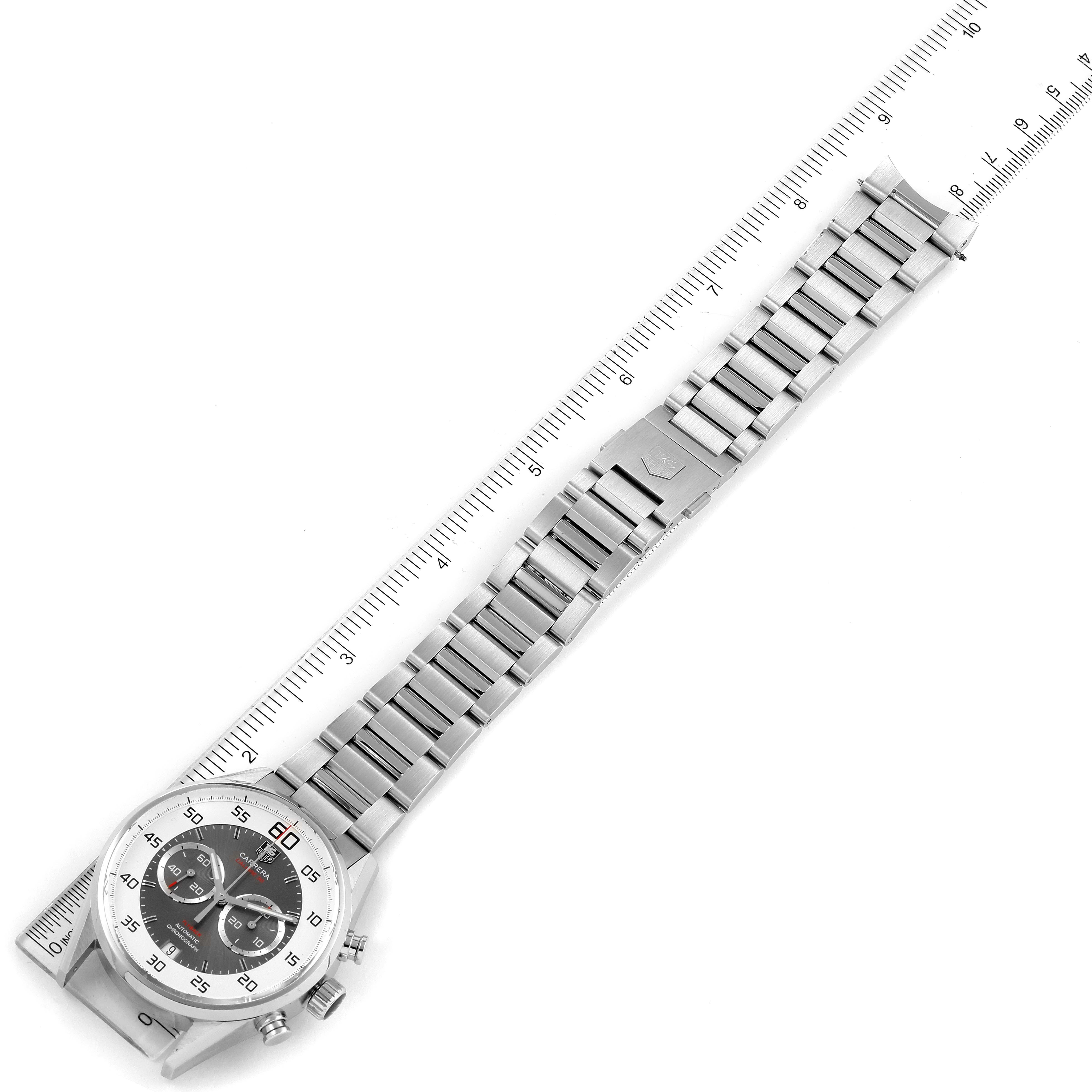 The image shows a Tag Heuer Carrera CAR2B11.BA0799 Men
s Stainless Steel Grey Dial CAR2B11.BA0799 Men
s Stainless Steel Grey Dial watch laid flat, highlighting its face, bracelet, and clasp, measured against a ruler.
