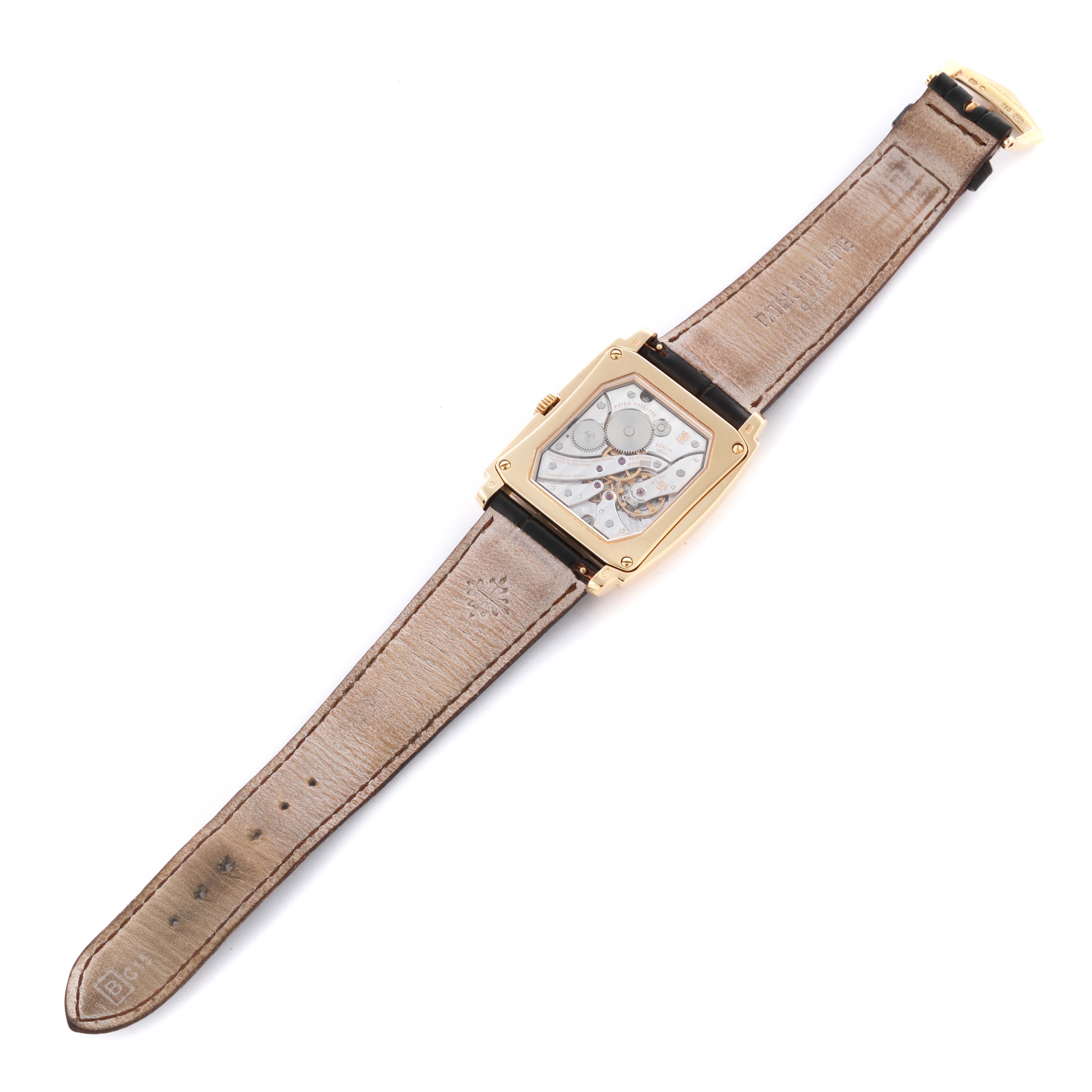 The watch is shown from the back, displaying the movement of the Patek Philippe Gondolo 5124J Men's Yellow Gold Silver Dial 5124J Men's Yellow Gold Silver Dial model, with the strap fully extended.