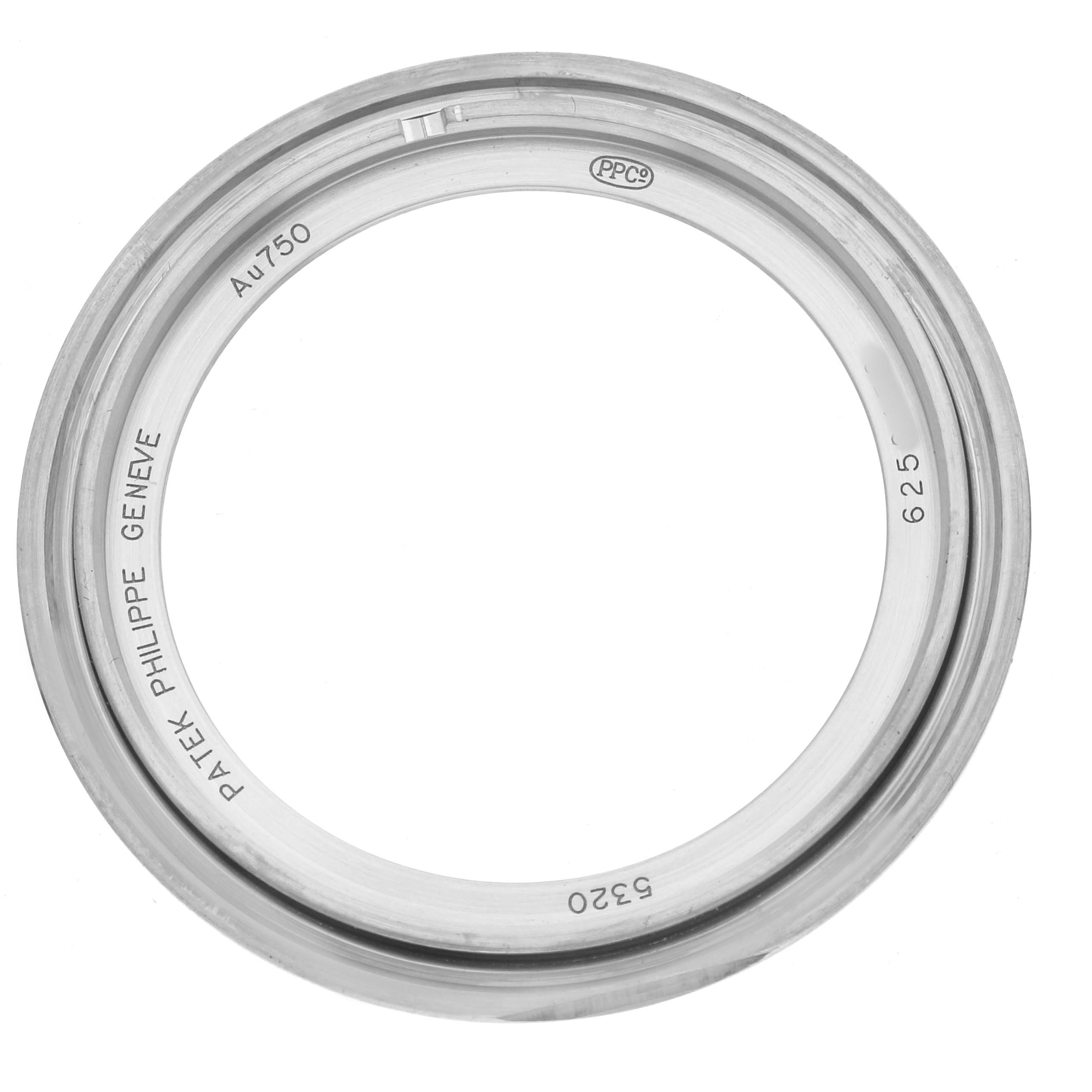 The image shows a Patek Philippe Complications 5320G Men's White Gold White Dial watch bezel viewed from above, displaying engravings and metal markings.