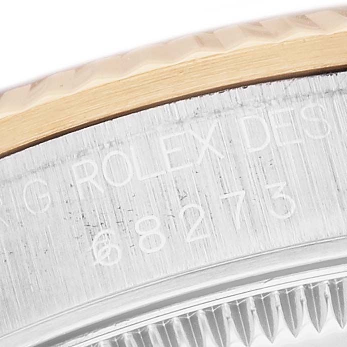 The image shows a close-up view of the Rolex Mid-Size 68273 Women
s Steel and Gold (two tone) Black Dial 68273 Women
s Steel and Gold (two tone) Black Dial watch, highlighting the bezel and engraved serial number.