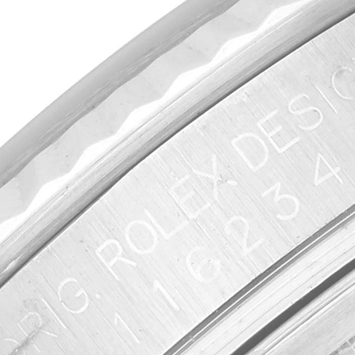The image shows an extreme close-up of the engraved inner bezel and fluted bezel edge of a Rolex Datejust 116234 Men's Stainless Steel Silver Dial 116234 Men's Stainless Steel Silver Dial watch.
