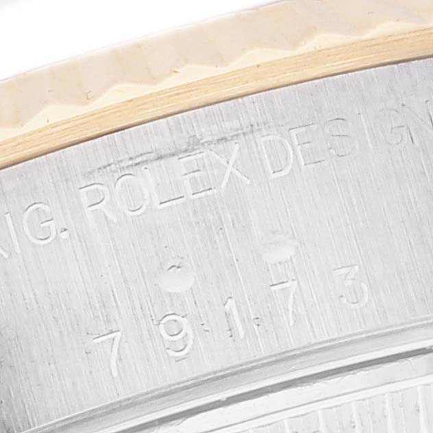 This close-up image shows the engraved serial number and part of the bezel of a Rolex Datejust 79173 Women's Steel and Gold (two tone) White Dial 79173 Women's Steel and Gold (two tone) White Dial.
