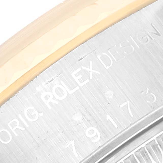 This close-up image shows the engraved side of the case of a Rolex Datejust 79173 Women's Steel and Gold (two tone) White Dial 79173 Women's Steel and Gold (two tone) White Dial watch.