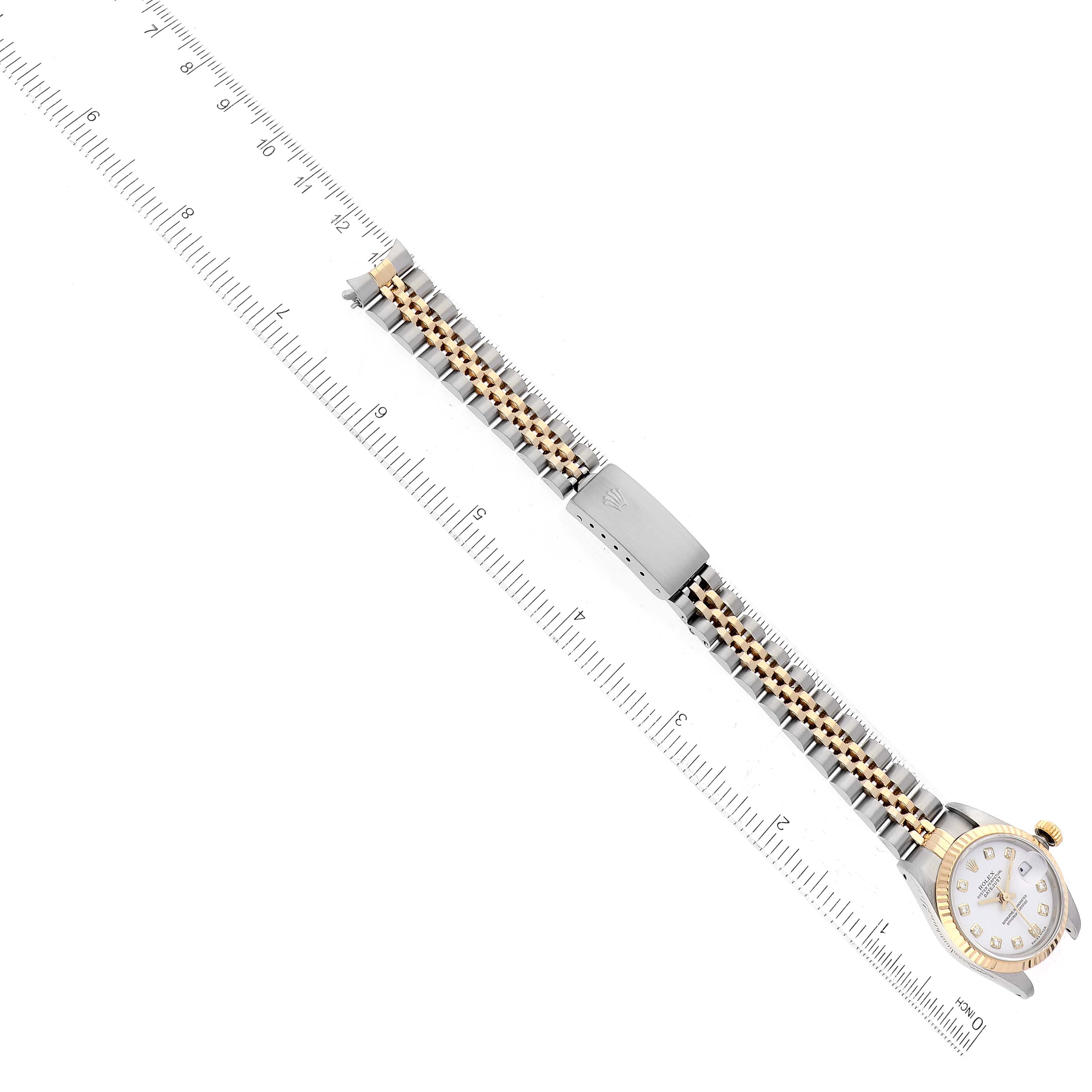 The image shows a top view of a Rolex Datejust 69173 Women's Steel and Gold (two tone) White Dial 69173 Women's Steel and Gold (two tone) White Dial watch with its bracelet band next to a ruler for scale.