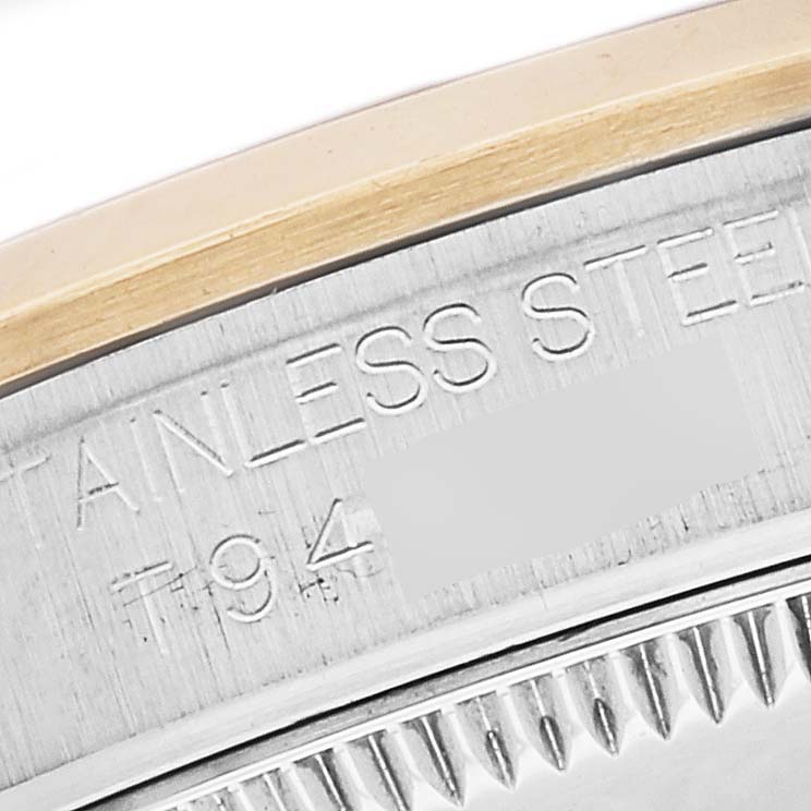 This close-up image shows the side engraving and part of the bezel of a Mid-Size Rolex watch.