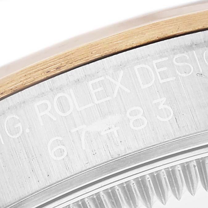 This image shows the side engraving and part of the bezel of a Rolex Mid-Size 67483 Women's Steel and Gold (two tone) Grey Dial 67483 Women's Steel and Gold (two tone) Grey Dial model watch.