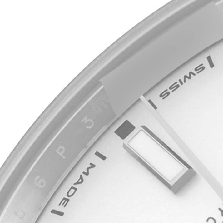 The image shows a partial view of the Rolex Oyster Perpetual 114300 Men's Stainless Steel Silver Dial 114300 Men's Stainless Steel Silver Dial watch face at an angle, focusing on the edge with "Swiss Made" text.