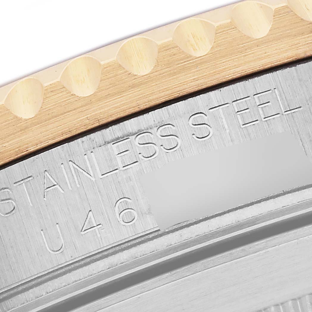 The image shows a close-up of the Rolex Submariner 16613 Men's Steel and Gold (two tone) Blue Dial 16613 Men's Steel and Gold (two tone) Blue Dial's stainless steel casing and gold bezel edge.