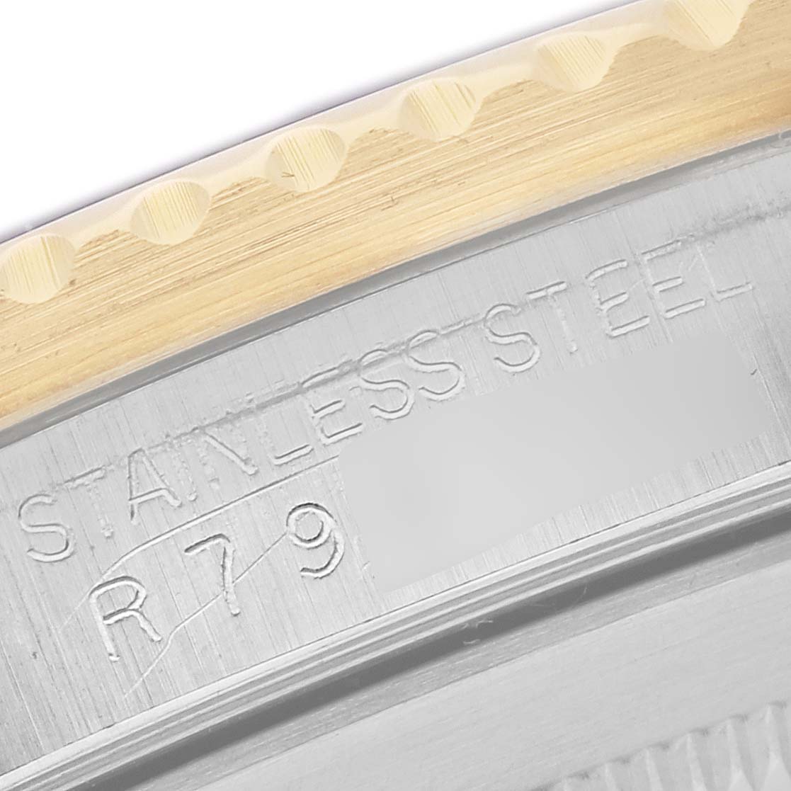 The angle shows a close-up of the Rolex Submariner 16803 Men's Steel and Gold (two tone) Blue Dial 16803 Men's Steel and Gold (two tone) Blue Dial's case edge, highlighting engravings and the bezel teeth.