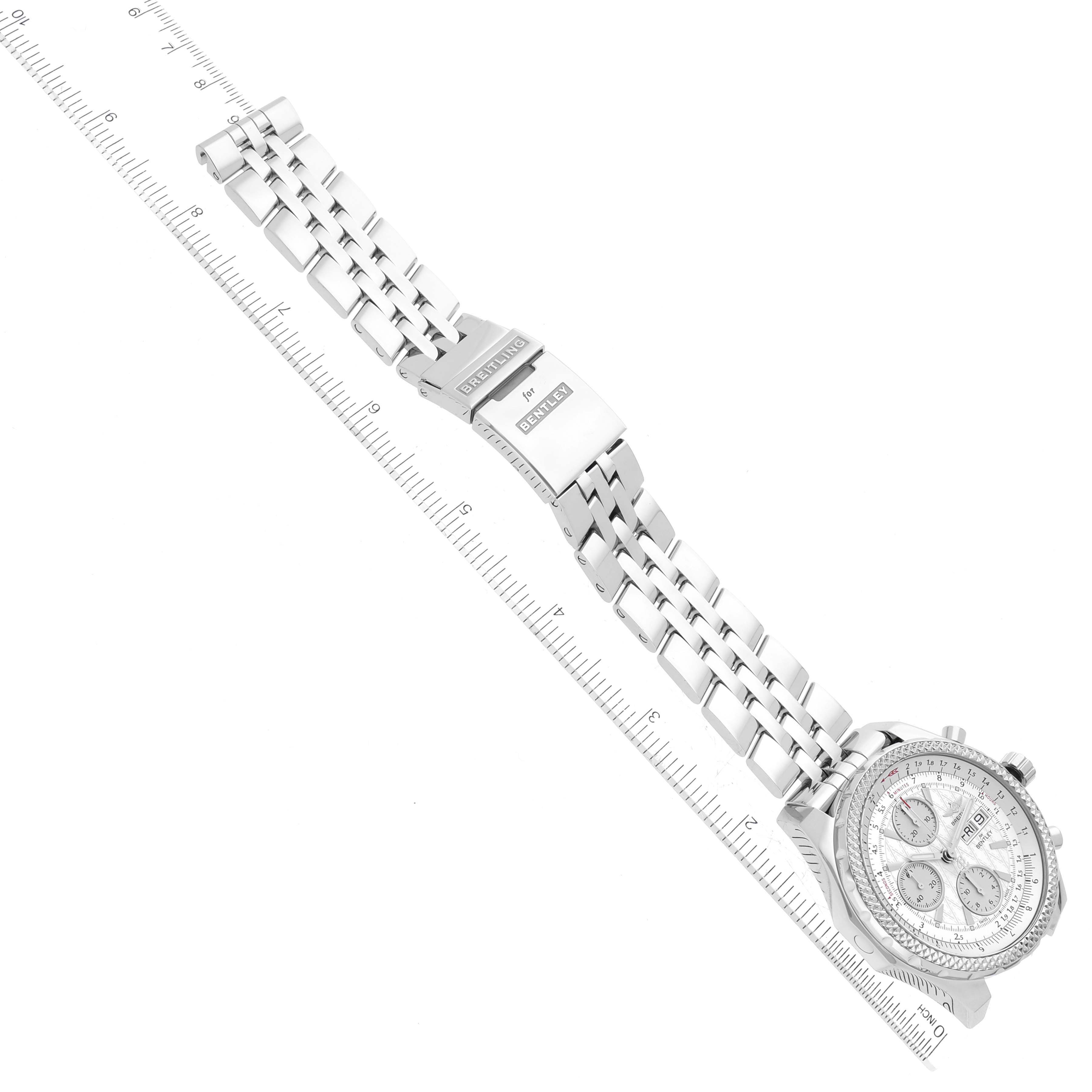 The image shows a Breitling Bentley A13362 Men's Stainless Steel White Dial A13362 Men's Stainless Steel White Dial watch at a diagonal angle, focusing on its strap and clasp with measuring ruler beside it.