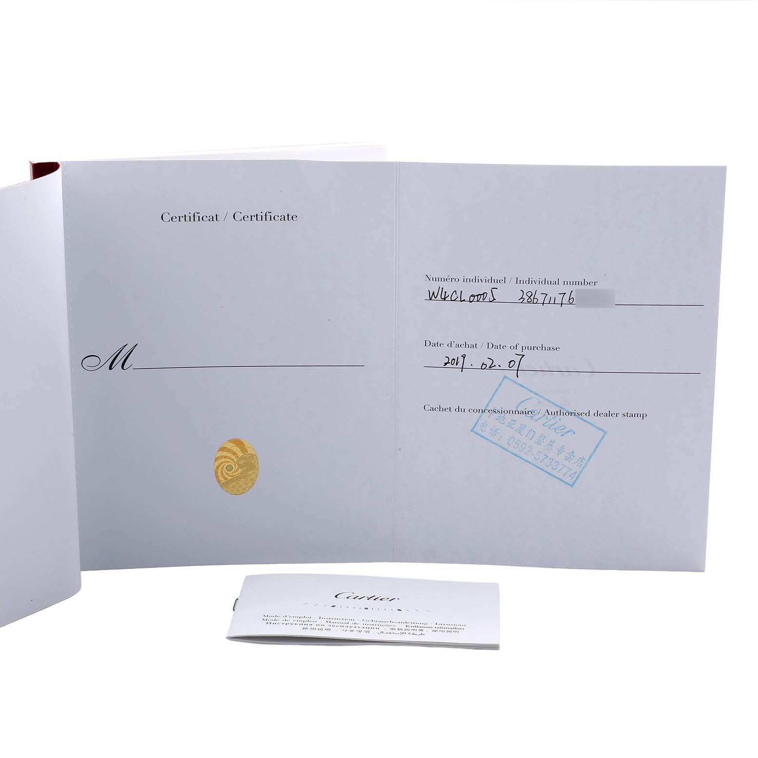The image shows the open certificate and warranty papers for the Cartier Clé model.
