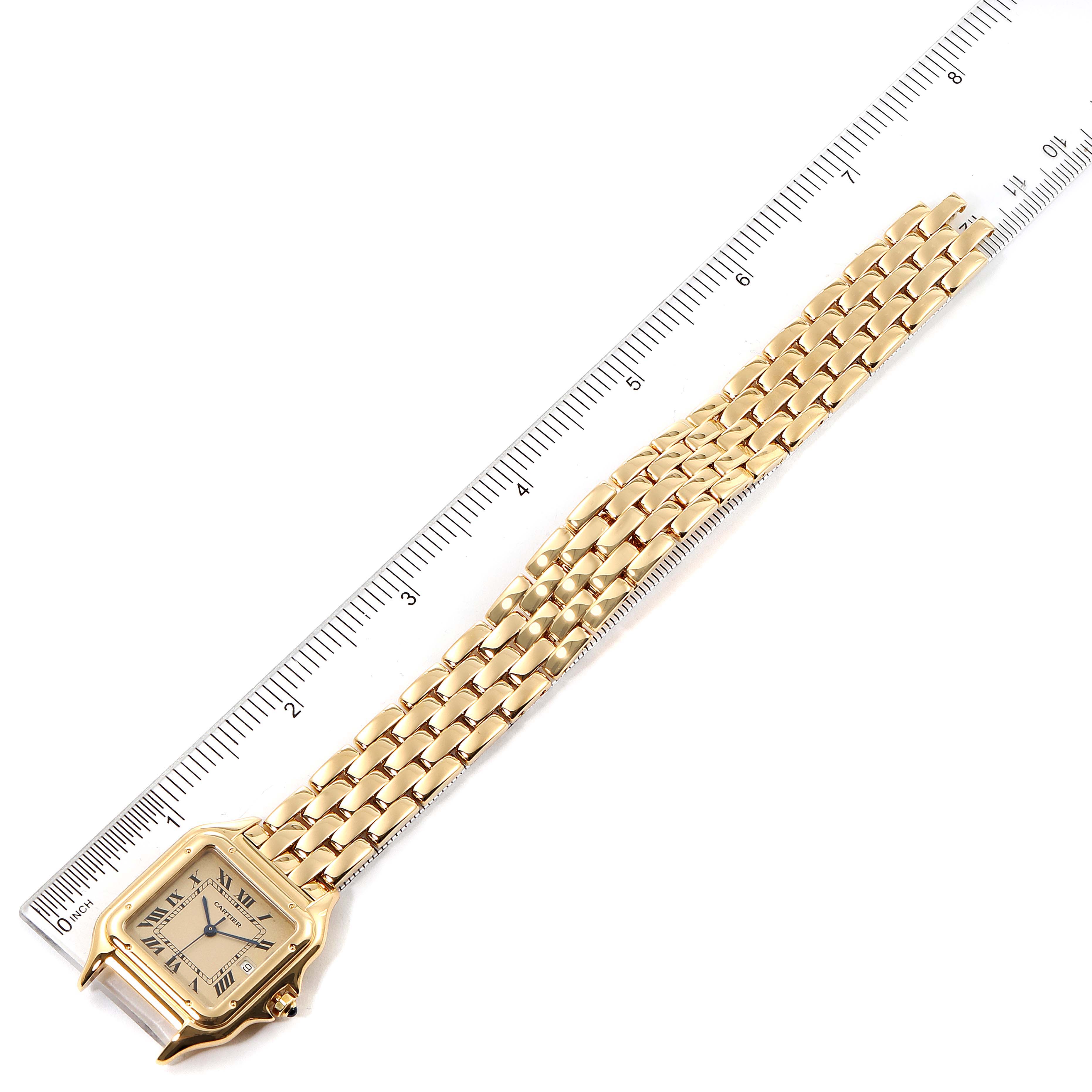 The image shows a top-down view of a Cartier Panthère watch, highlighting its gold case, bracelet, and a ruler for scale.