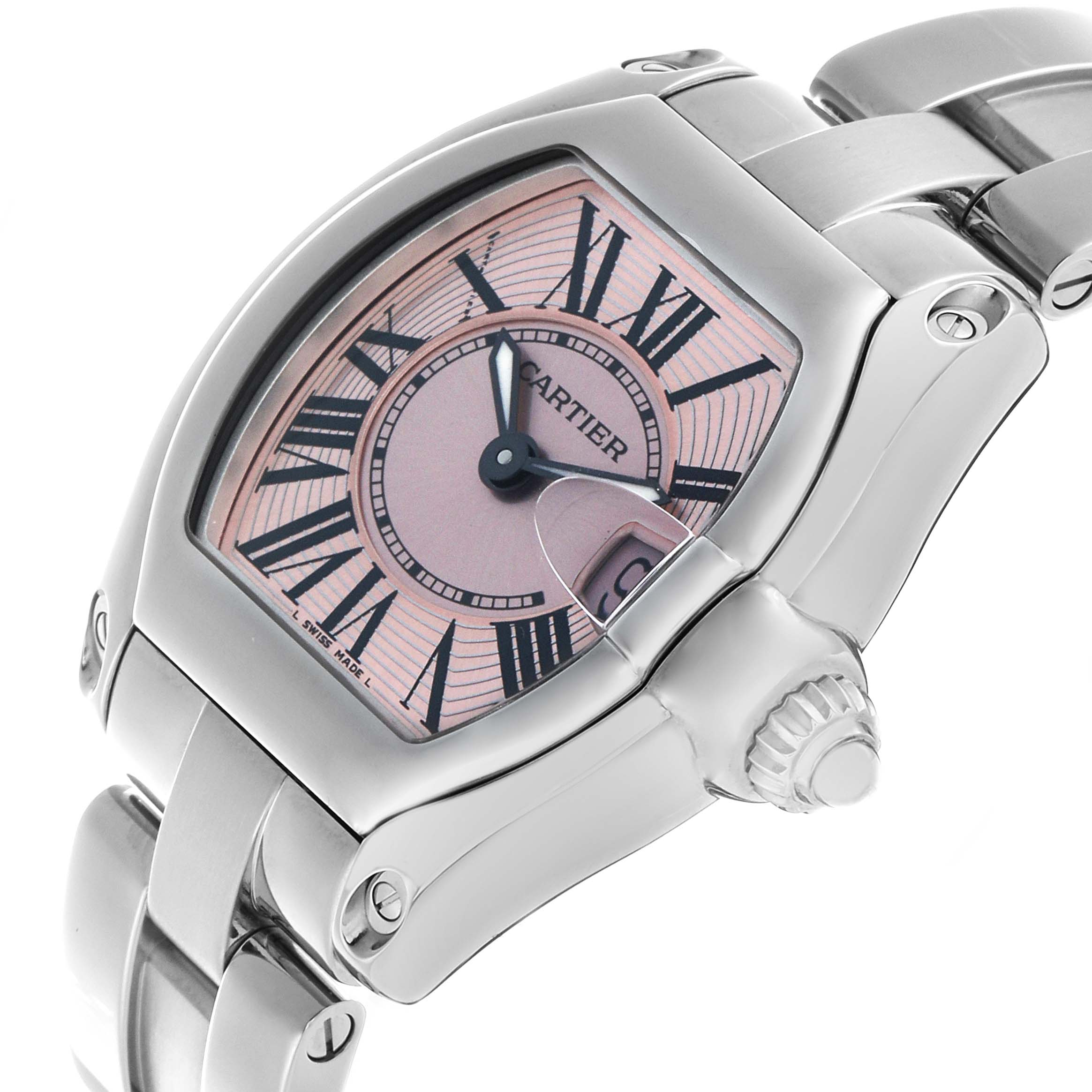 The Cartier Roadster W62017V3 Women's Stainless Steel Pink Dial watch is shown from a front-right angle, highlighting its pink dial, Roman numerals, and metal bracelet.