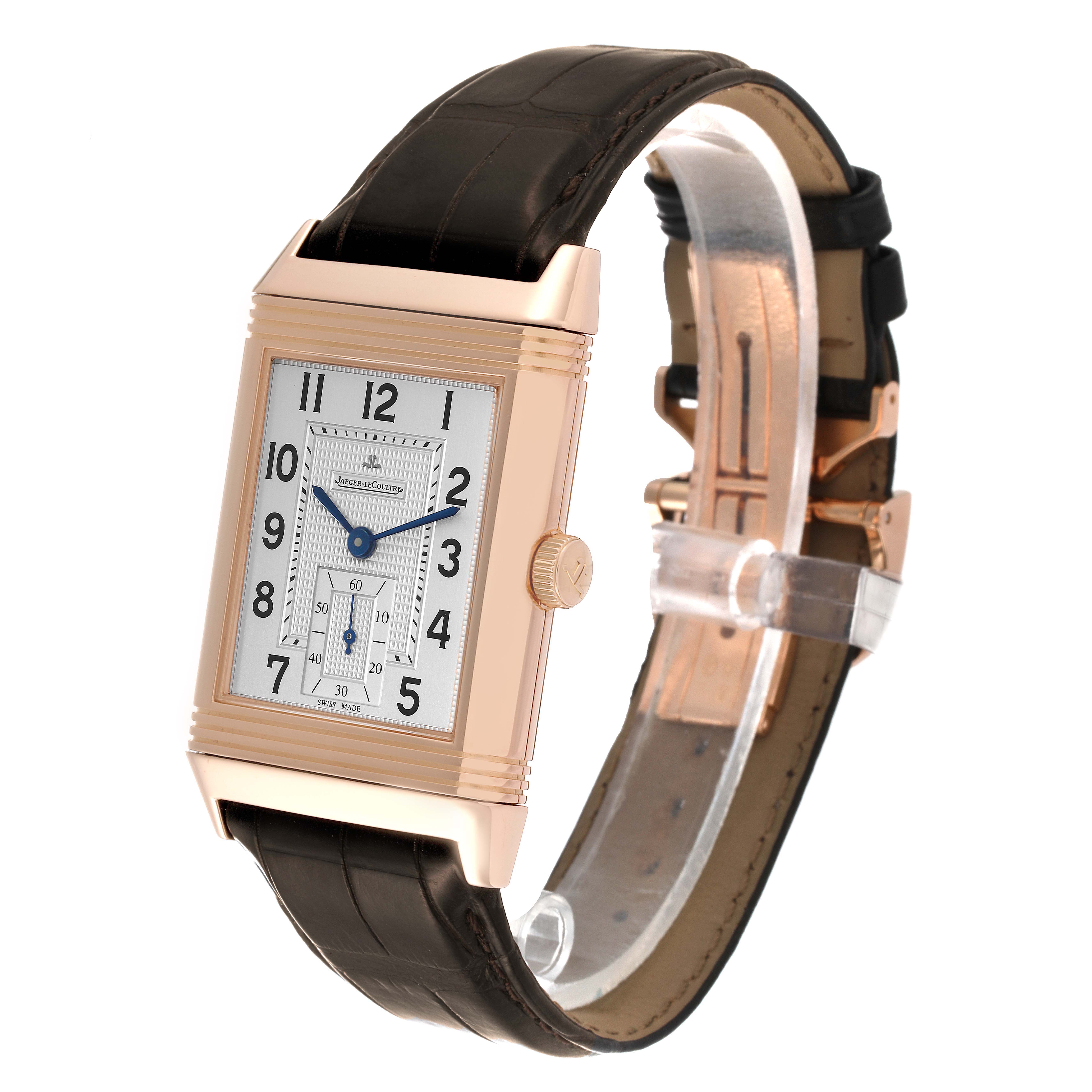 The Jaeger-LeCoultre Reverso watch is shown at a three-quarter angle highlighting the dial, case, crown, and leather strap.