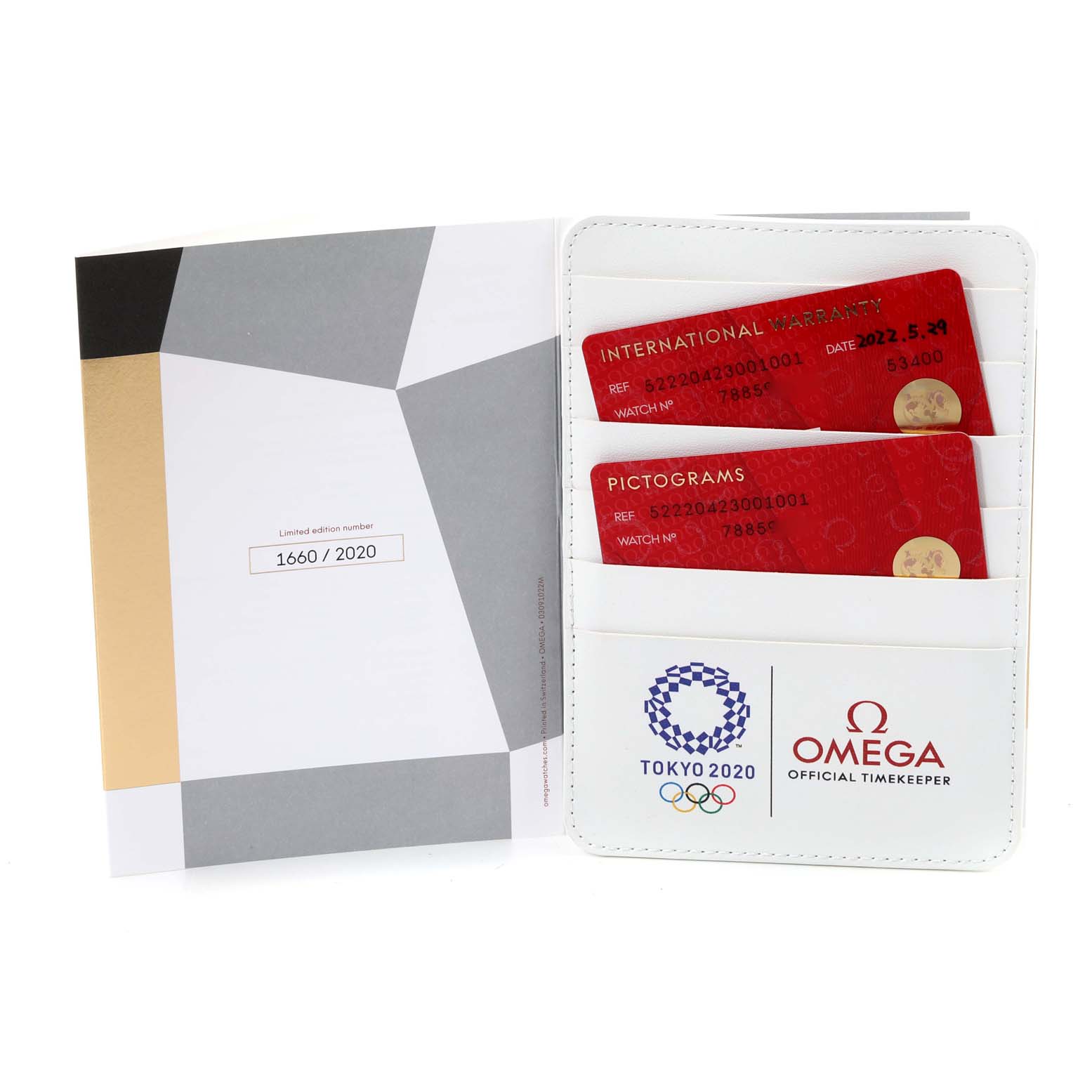 The image shows warranty and pictogram cards, and a certificate booklet for the Omega Speedmaster 522.20.42.30.01.001 Men
s Steel and Gold (two tone) Black Dial 522.20.42.30.01.001 Men
s Steel and Gold (two tone) Black Dial Tokyo 2020 limited edition.