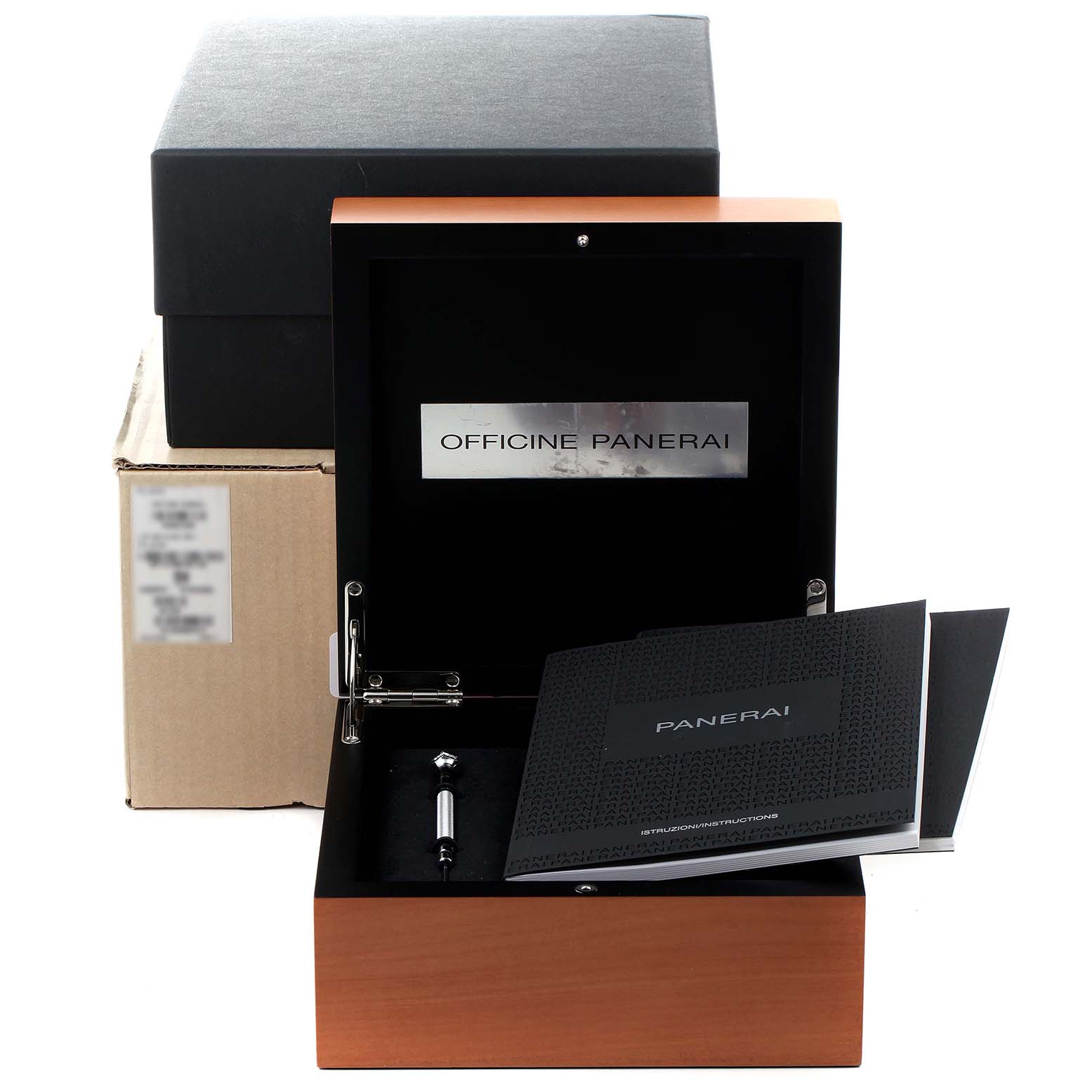 This image shows an open box for a Panerai Luminor PAM01535 Men
s Stainless Steel Black Dial PAM01535 Men
s Stainless Steel Black Dial watch with accompanying literature and accessories, including a tool.