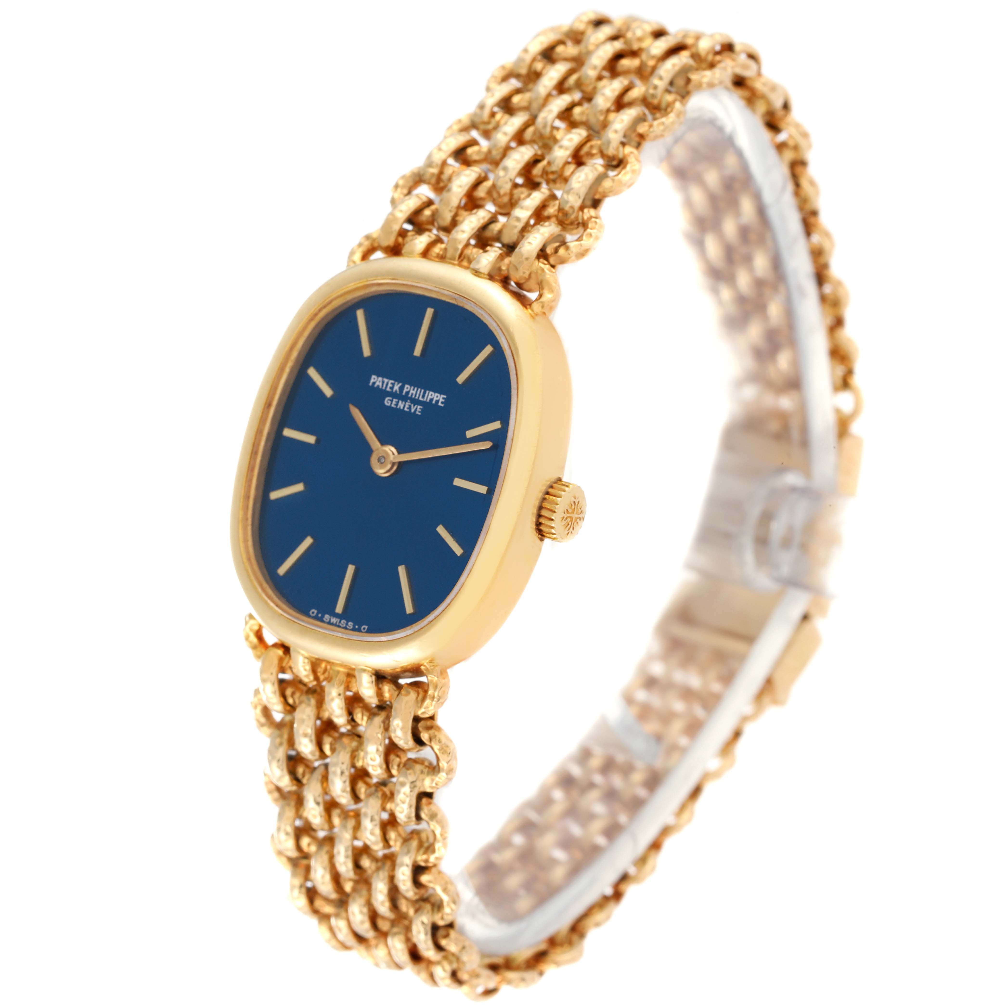 This image shows a Patek Philippe Golden Ellipse 4464/4 Women's Yellow Gold Blue Dial 4464/4 Women's Yellow Gold Blue Dial watch at a slight side angle, highlighting its blue dial, gold case, and intricate gold bracelet.