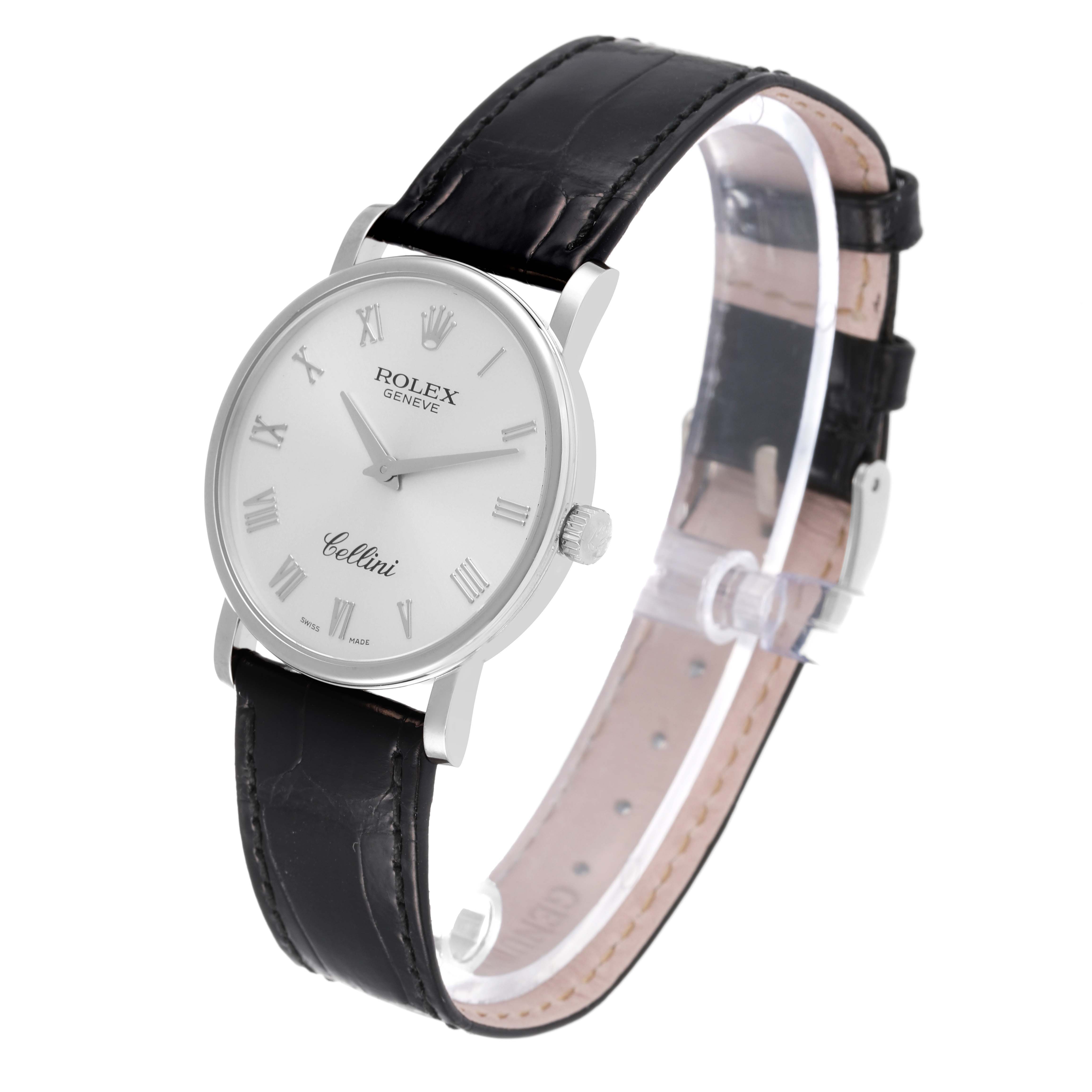 The Rolex Cellini 5115/9 Men
s White Gold Silver Dial 5115/9 Men
s White Gold Silver Dial watch is depicted at a slight angle, featuring its white dial, Roman numeral markers, and black leather strap.