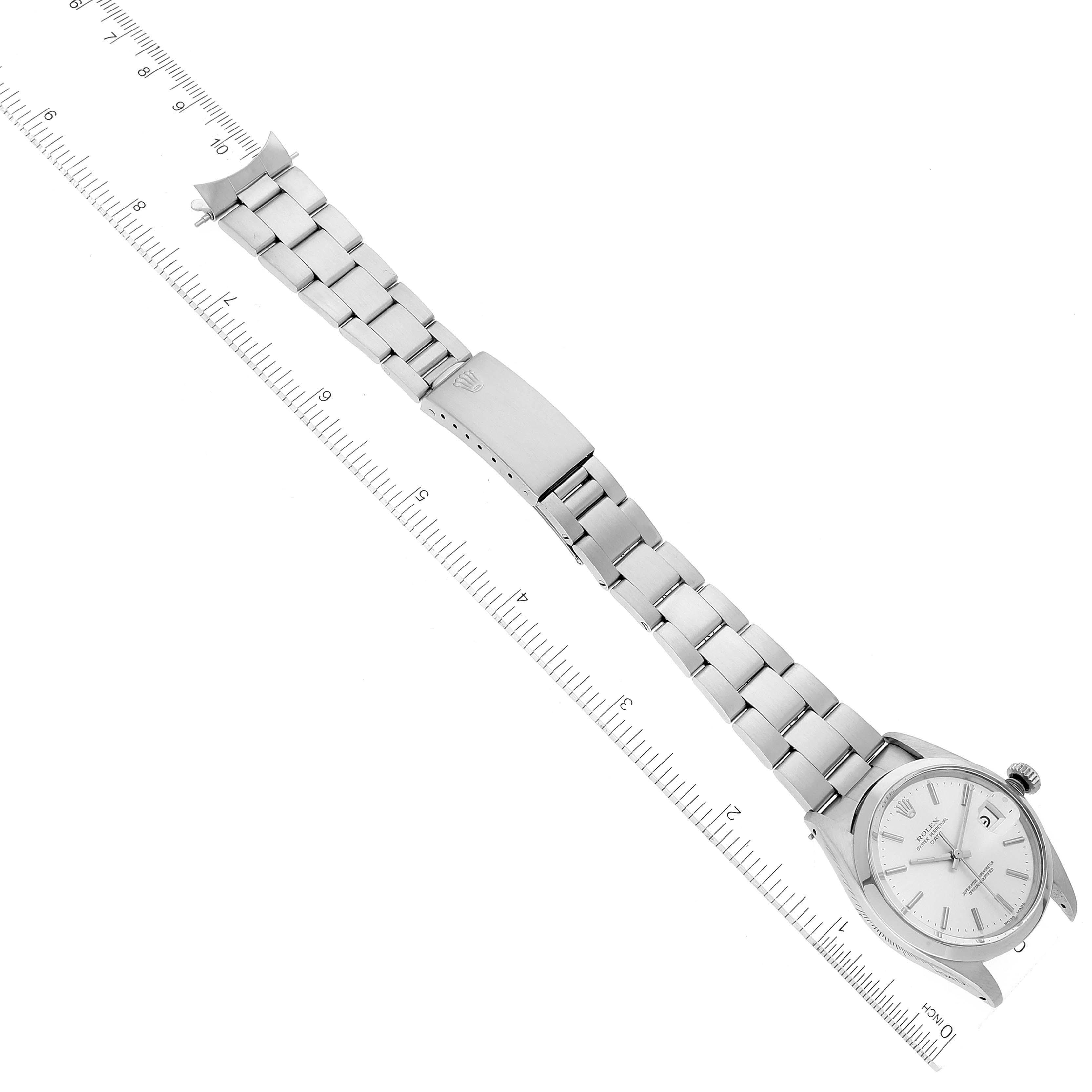 The Rolex Vintage Collection 1500 Men
s Stainless Steel Silver Dial 1500 Men
s Stainless Steel Silver Dial watch is shown from a top-down angle, displaying its full bracelet and clasp alongside a ruler.