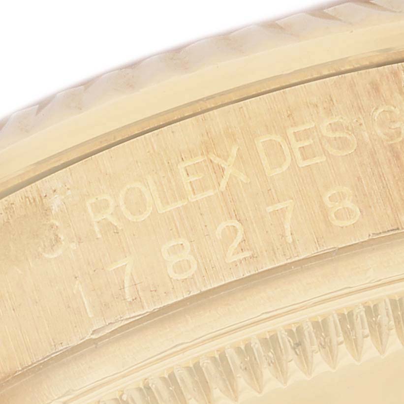 This close-up image shows the edge of the case with engraved text of a Rolex President 178278 Women
s Yellow Gold Black Dial 178278 Women
s Yellow Gold Black Dial model watch.