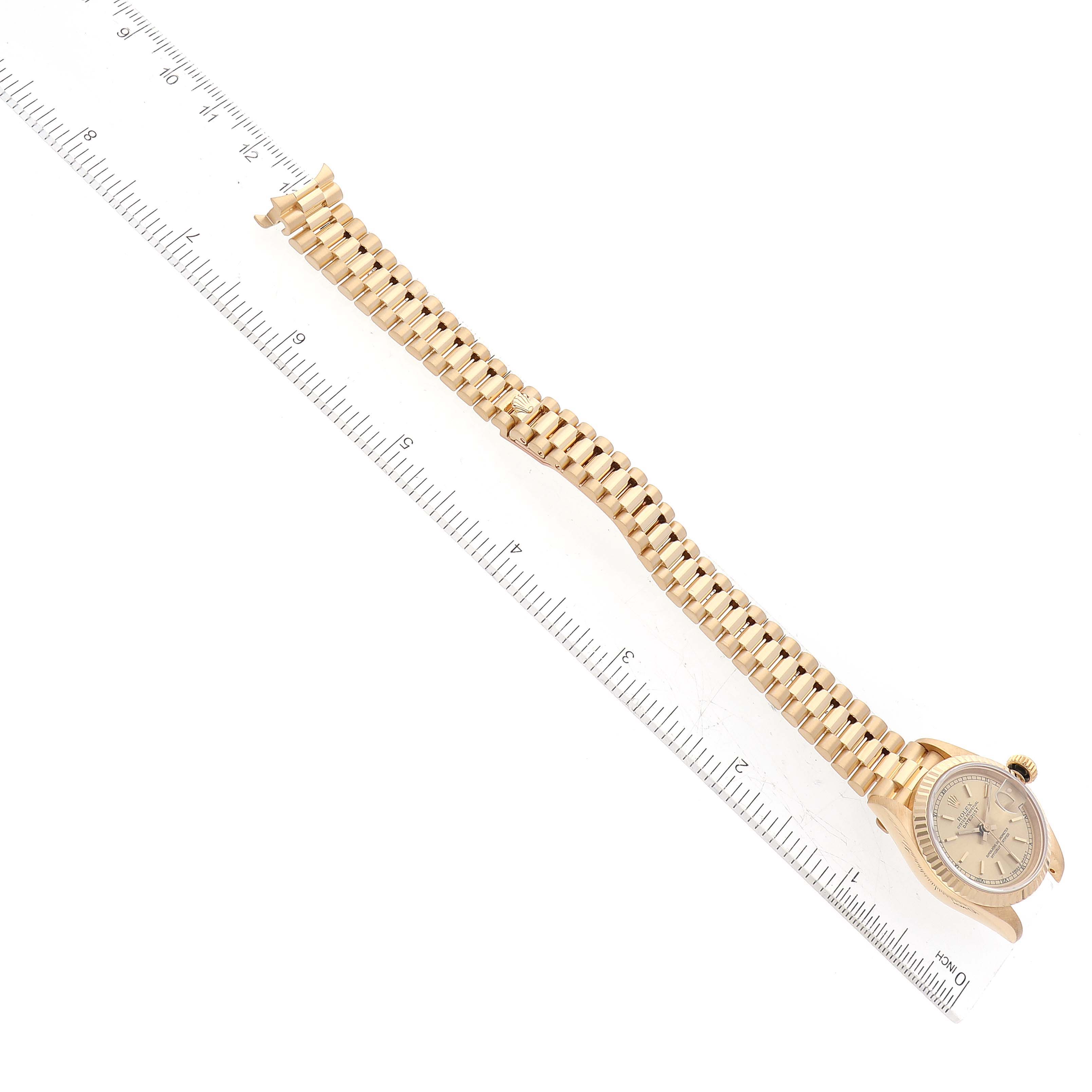 The image shows a Rolex President 69178 Women's Yellow Gold Champagne Dial 69178 Women's Yellow Gold Champagne Dial model watch photographed from above, highlighting the bracelet and dial next to a ruler for scale.