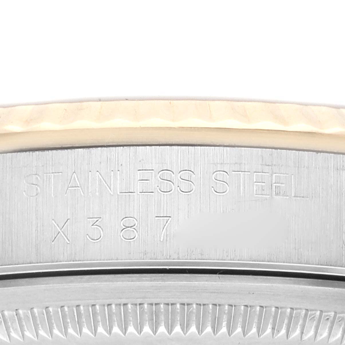 The image shows a close-up of the case back and edge of the bezel of a Rolex Datejust 16233 Men's Steel and Gold (two tone) Champagne Dial 16233 Men's Steel and Gold (two tone) Champagne Dial model, highlighting the stainless steel engravings.
