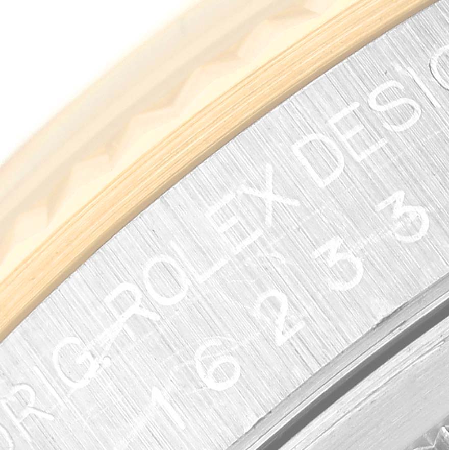 This close-up image shows part of the bezel and engraved text on the case of a Rolex Datejust 16233 Men's Steel and Gold (two tone) Champagne Dial 16233 Men's Steel and Gold (two tone) Champagne Dial watch.
