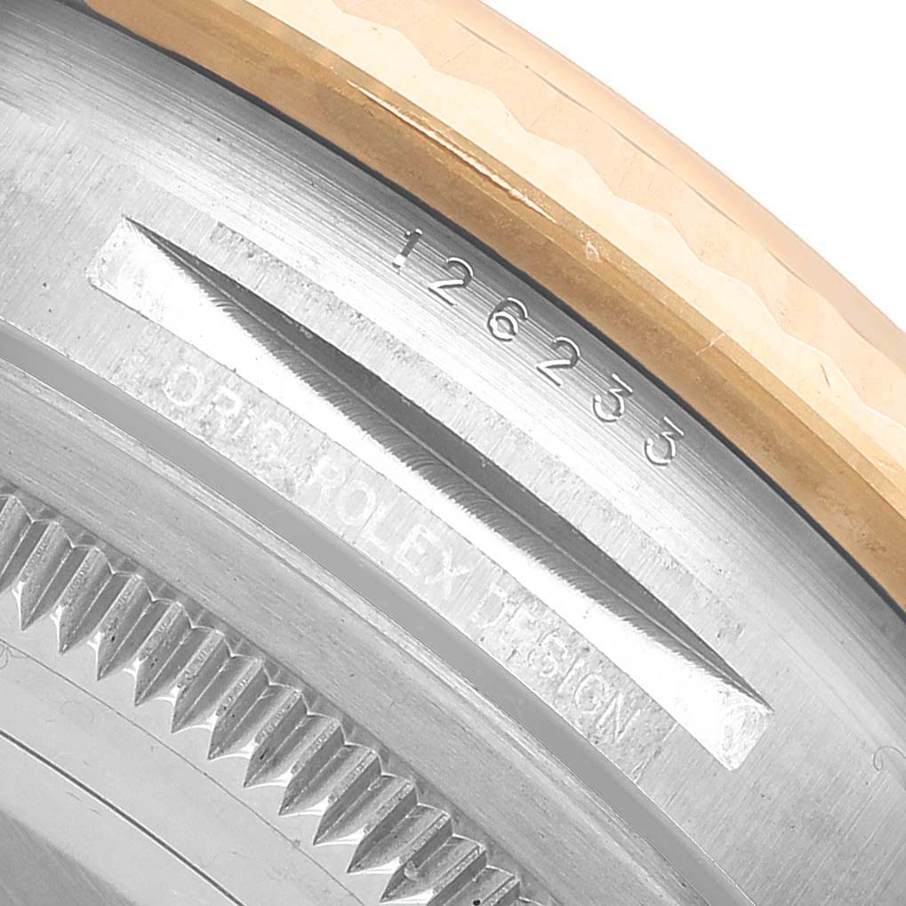 The image shows a close-up of the Rolex Datejust 126233 Men's Steel and Gold (two tone) Champagne Dial's serial number and fluted bezel edge.