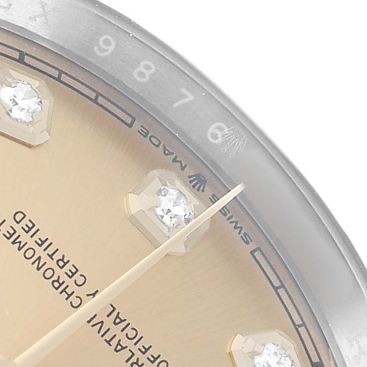 The image shows a close-up of the Rolex Datejust 126233 Men's Steel and Gold (two tone) Champagne Dial watch dial with diamond hour markers, partial hands, and the edge of the bezel.