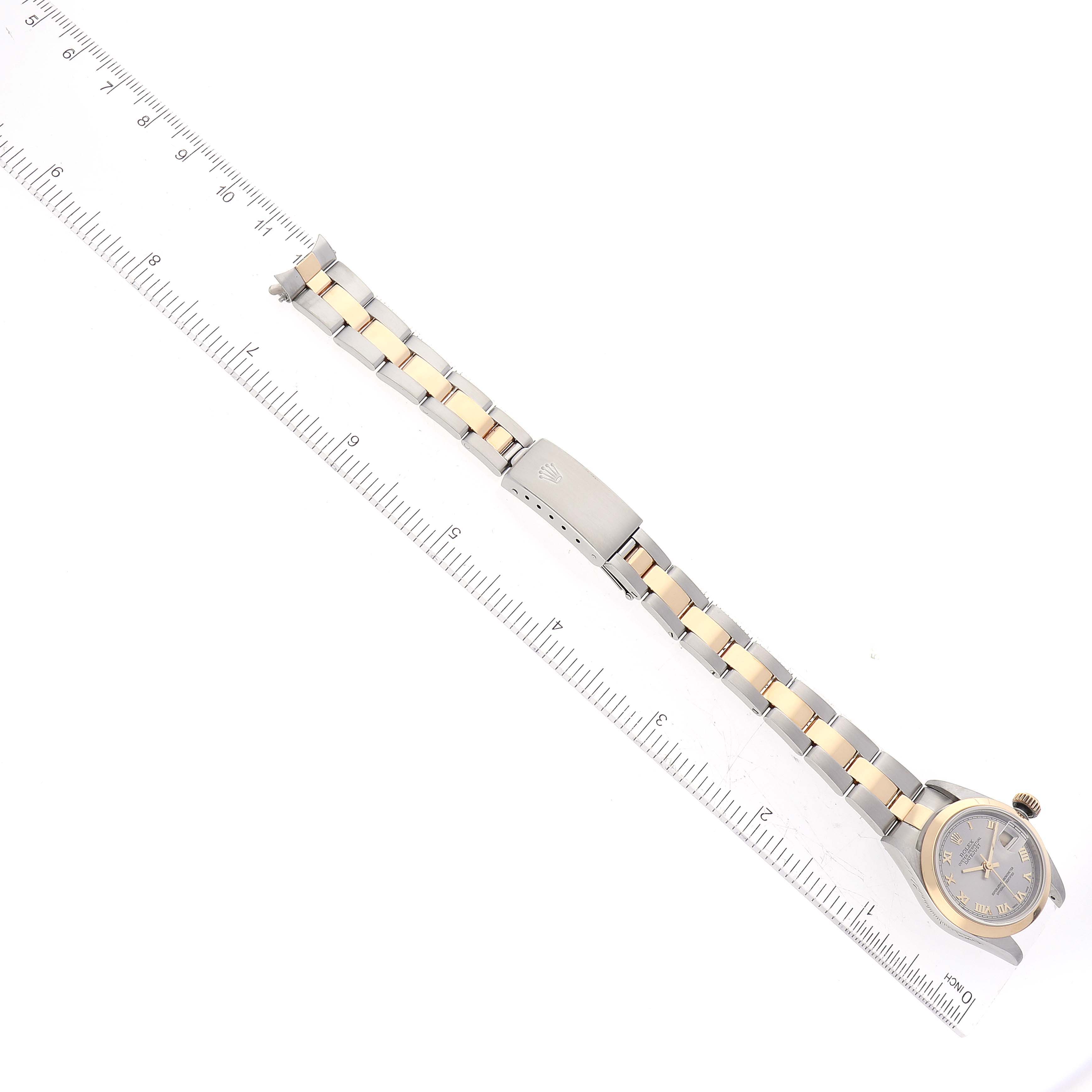 This image shows a Rolex Datejust 79163 Women's Steel and Gold (two tone) Grey Dial 79163 Women's Steel and Gold (two tone) Grey Dial watch with the dial, bracelet, and clasp clearly visible, displayed next to a ruler.