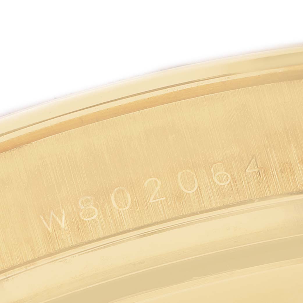 The image shows a close-up of the gold-tone edge with an inscription on the Rolex Daytona 16528 Men's Yellow Gold Champagne Dial watch.