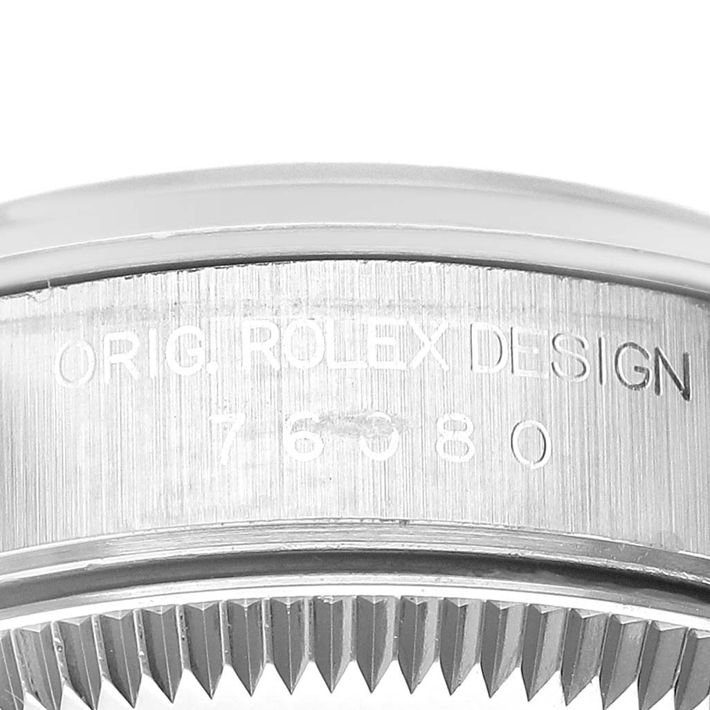 The image shows a close-up shot of the engraved case side and bezel of a Rolex Oyster Perpetual 76080 Women's Stainless Steel Blue Dial 76080 Women's Stainless Steel Blue Dial watch.