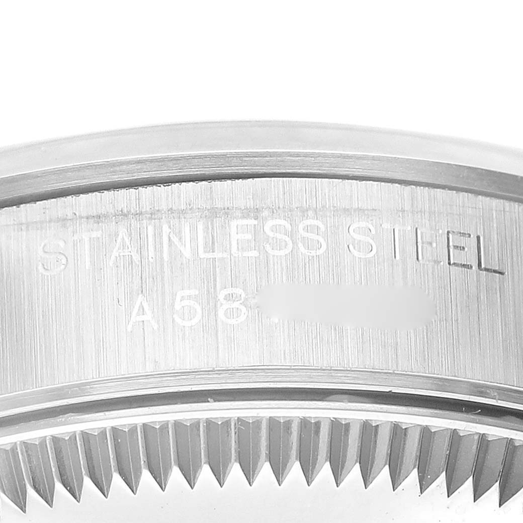 The image shows a close-up of the case edge and part of the bezel of a Rolex Oyster Perpetual 76080 Women's Stainless Steel Blue Dial 76080 Women's Stainless Steel Blue Dial watch, with "STAINLESS STEEL" engraved.