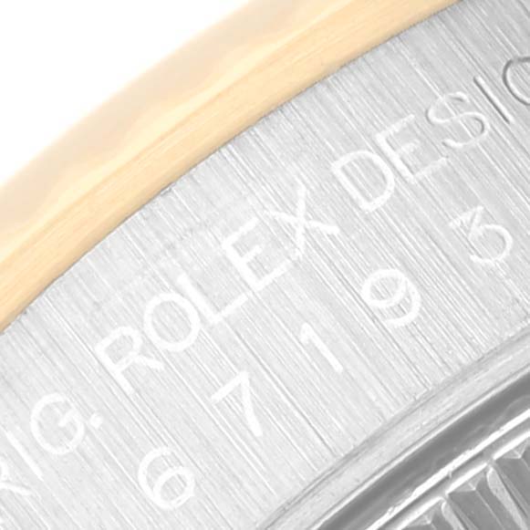 The image shows a close-up of the engraving on the side of the case for the Rolex Oyster Perpetual 67193 Women's Steel and Gold (two tone) Black Dial 67193 Women's Steel and Gold (two tone) Black Dial watch.