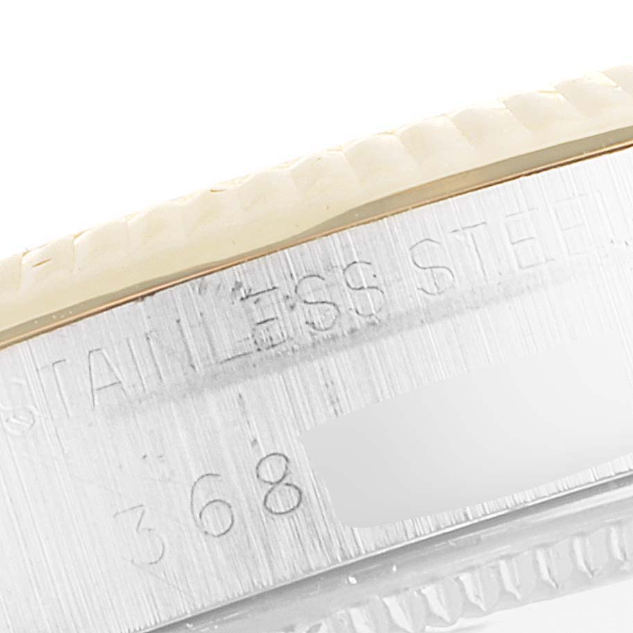 A close-up angle showing the side case and part of the bezel of the Rolex Vintage Collection 1002 Men
s Steel and Gold (two tone) Champagne Dial 1002 Men
s Steel and Gold (two tone) Champagne Dial watch with "STAINLESS STEEL" inscribed.