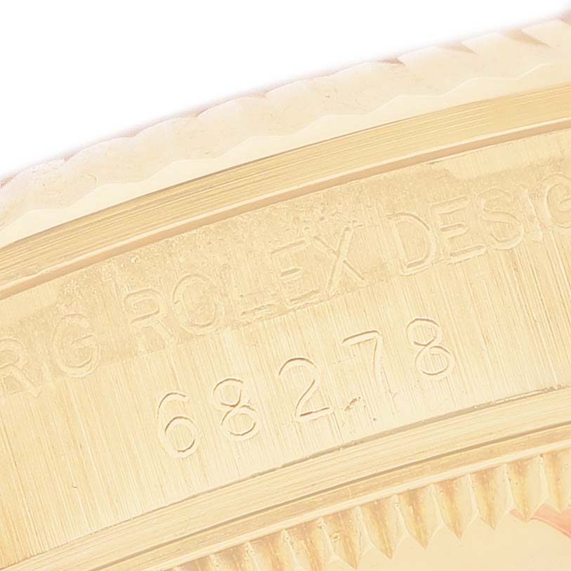 The image shows the edge of the bezel and part of the engraving on a Rolex President 68278 Women's Yellow Gold Black Dial model watch, viewed up close.