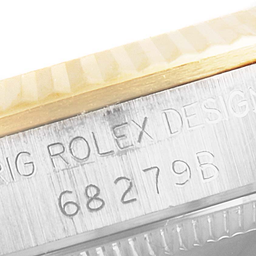The image shows a close-up of the Rolex President 68279 Women's White Gold Brown Dial 68279 Women's White Gold Brown Dial model, highlighting the engraved serial number and part of the bezel.