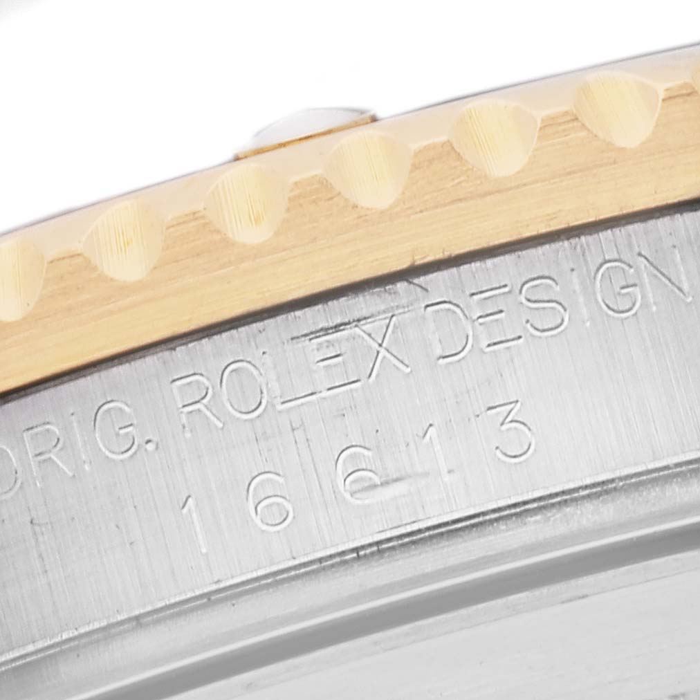 The image shows a close-up of the side engraving on the bezel and case of a Rolex Submariner 16613 Men's Steel and Gold (two tone) Blue Dial 16613 Men's Steel and Gold (two tone) Blue Dial.